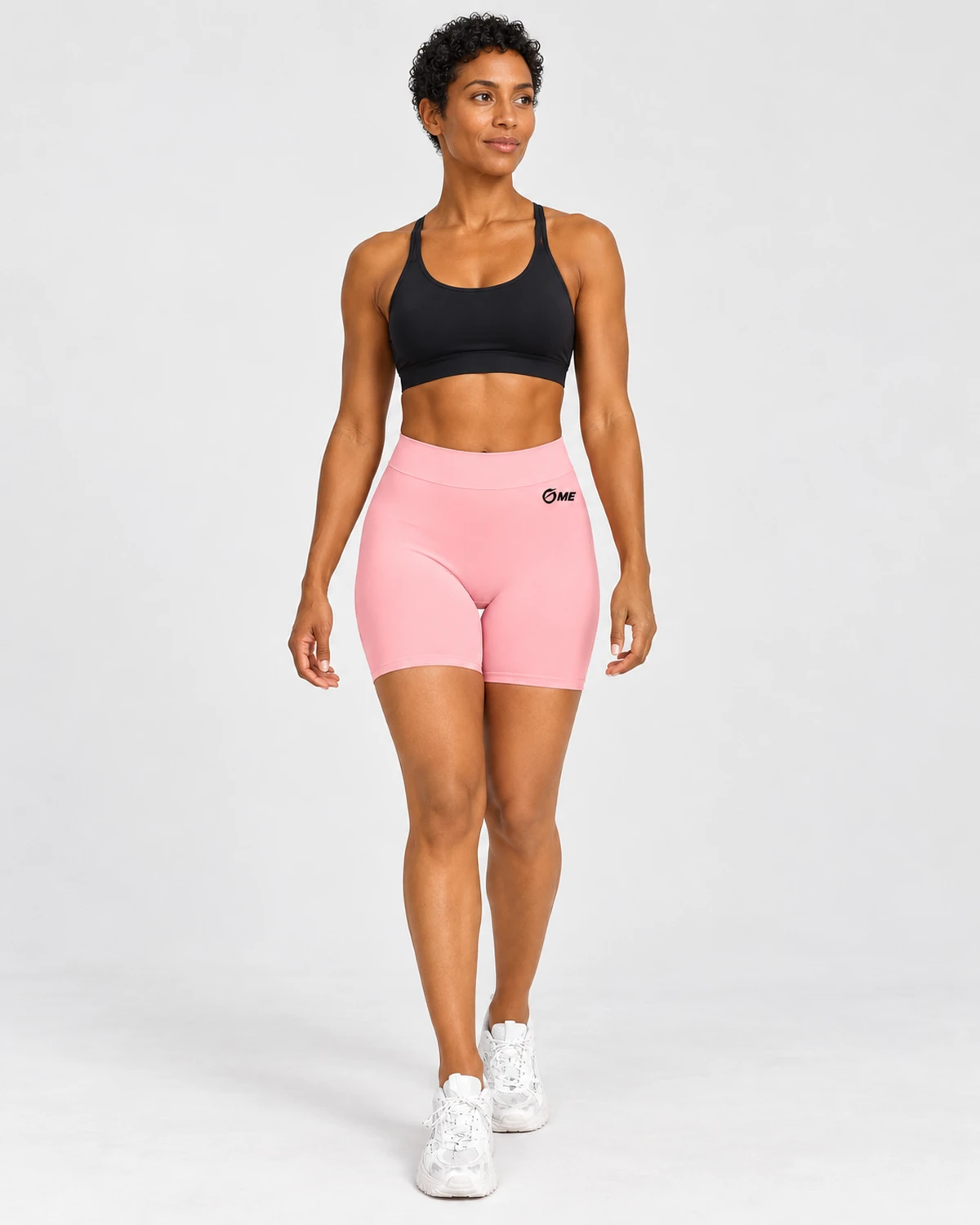 Pantalón corto ABDERA rosa claro con logo OME negro, vista frontal con modelo.