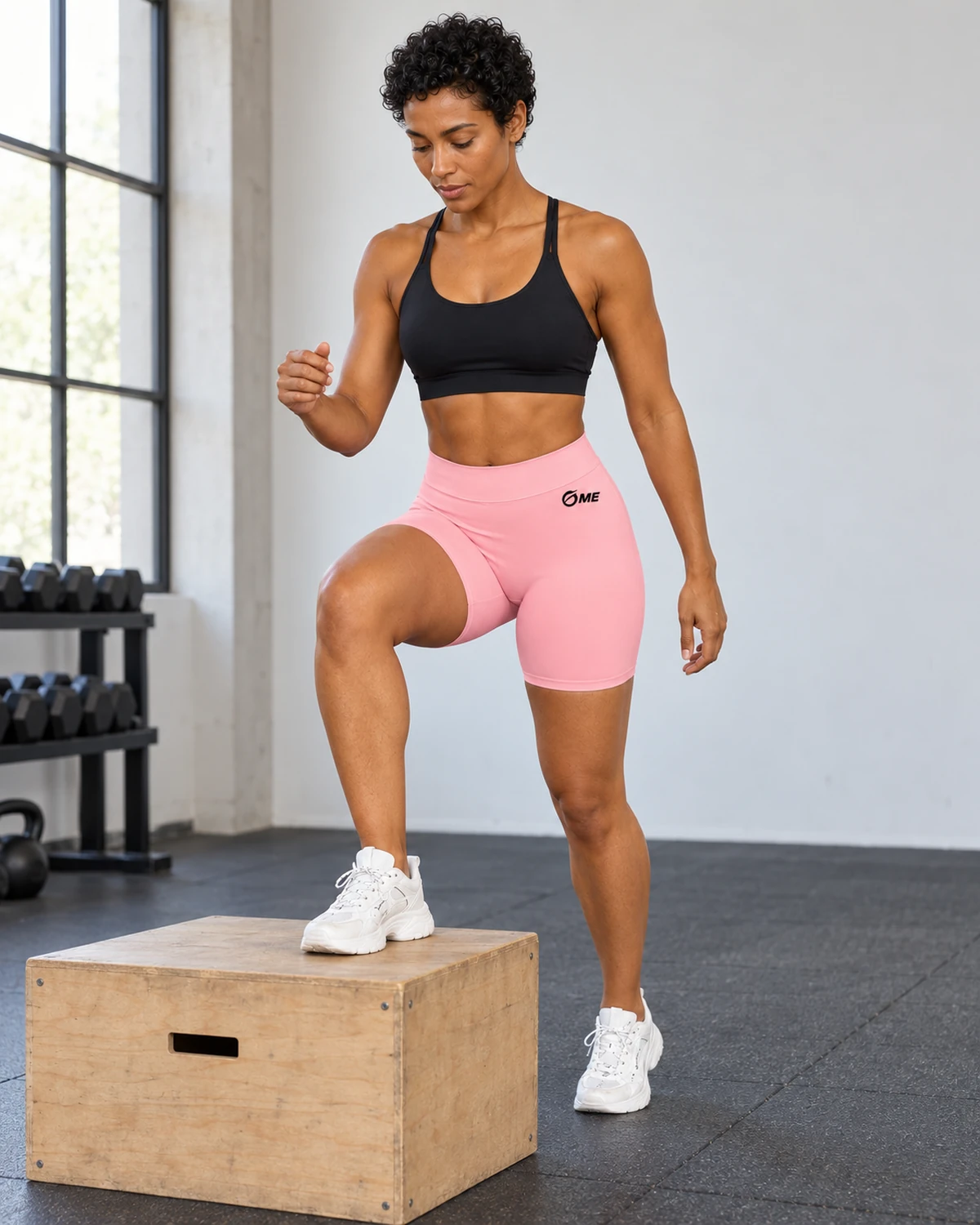 Pantalón corto ABDERA rosa claro durante una subida a cajón de madera en el gimnasio.